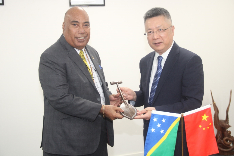 Permanent Secretary of the Ministry of Foreign Affairs and External Trade, Collin Beck hands over a gift to the visiting People’s Republic of China’s (PRC) Special Envoy for Pacific Island Countries Affairs, His Excellency, Qian Bo.